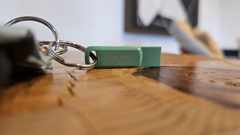 A teal SanDisk flash drive on a keychain.