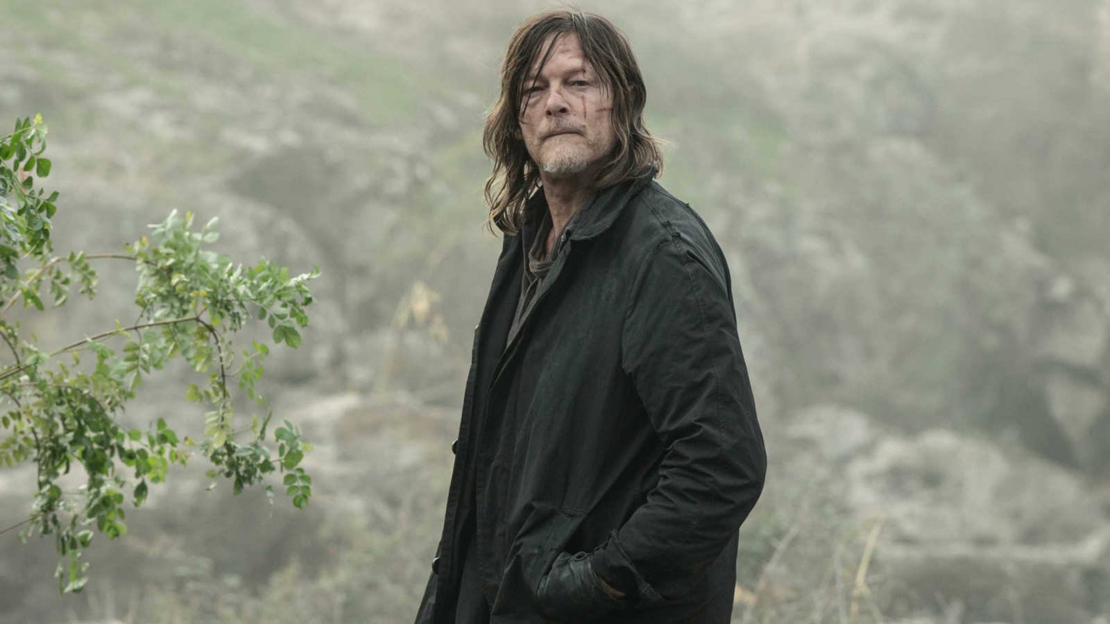 Norman Reedus as Daryl Dixon with his hands in his jacket pocket looking into the distance in The Walking Dead: Daryl Dixon season 3