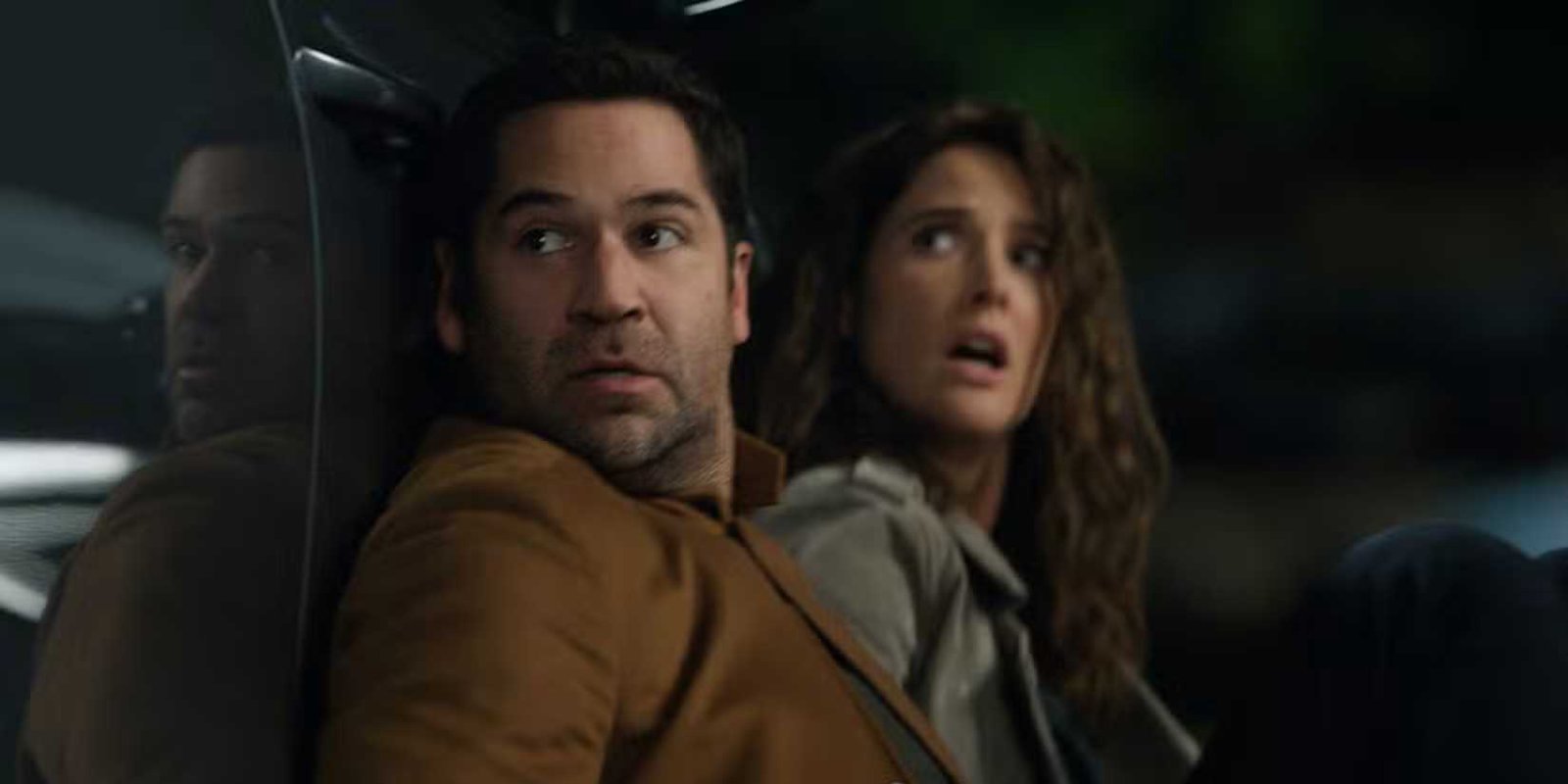Mickey Haller and Emi Finch hide behind a car at the end of The Lincoln Lawyer season 4