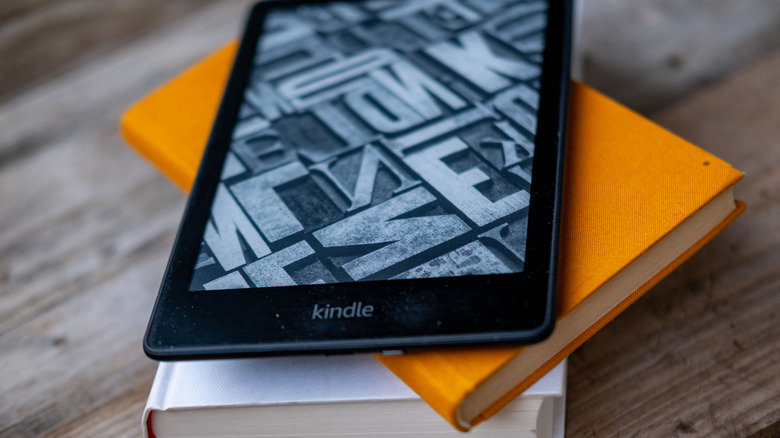 Kindle Lifespan Explained: How Many Years Will Your E-Reader Really Last? 28 A Kindle laying on top of a couple of books, on a wooden table.