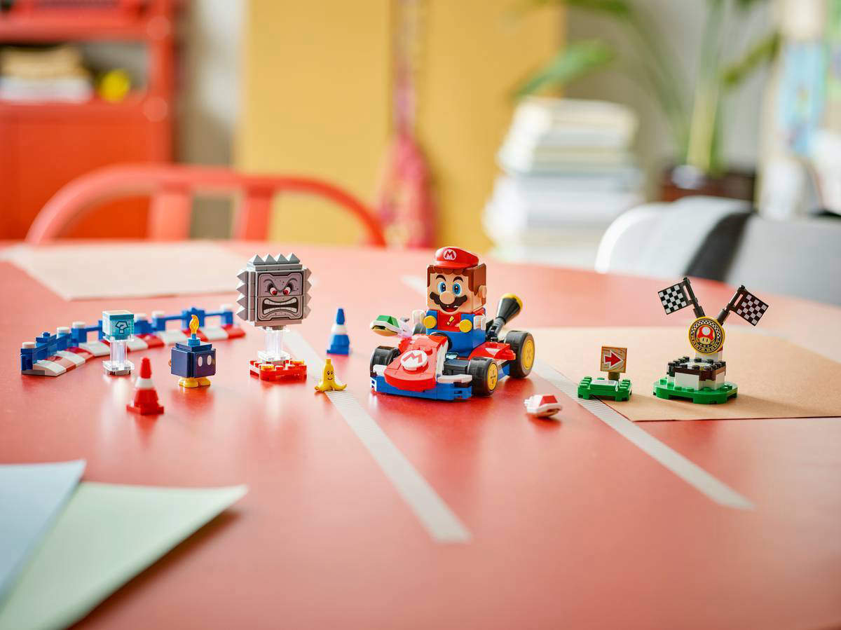 A Nintendo Super Mario LEGO set featuring Mario Kart laid out on a table